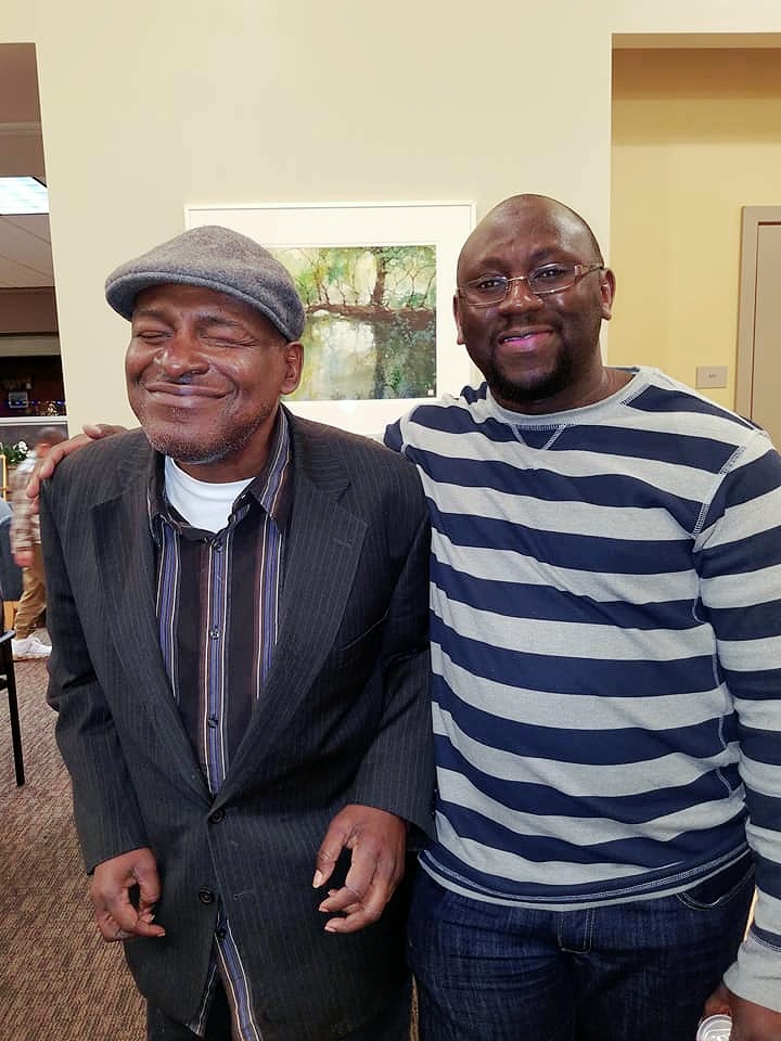 Two Black men in causual dressy clothes are smiling