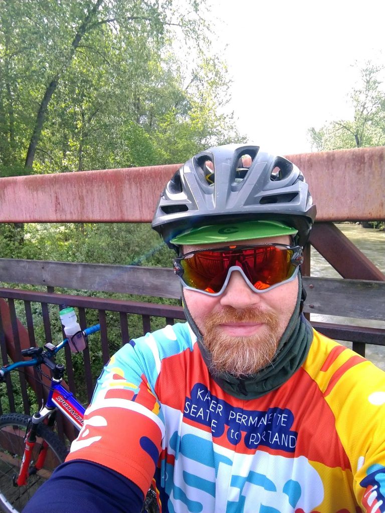 A man with a bike helmet and biking gear is on his bike.