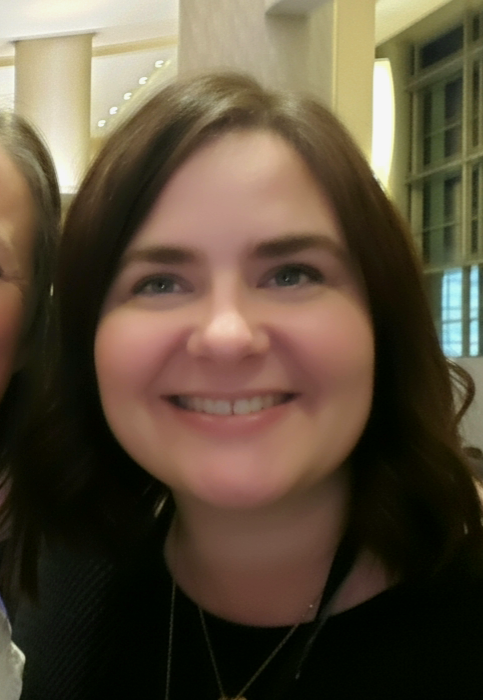 A woman with medium length brown hair is smiling. This is Stephanie, the Training Coordinator at TLC.